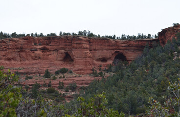 Fototapeta na wymiar Caves Carved into the Red Rock Cliffs