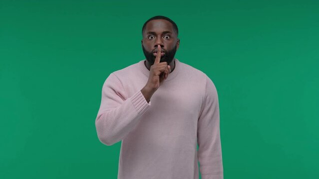 African American man showing hush gesture isolated on Green Screen, Chroma Key background, keeping finger on lips, privacy