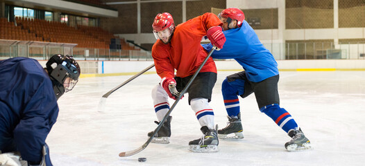 Hockey players playing hockey in the ice rink in winter	