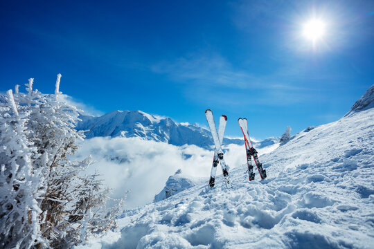 Sun at mountains and still image of alpine ski in snow