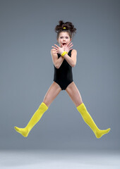 girl jumping and laughting in studio, rythmic gymnast