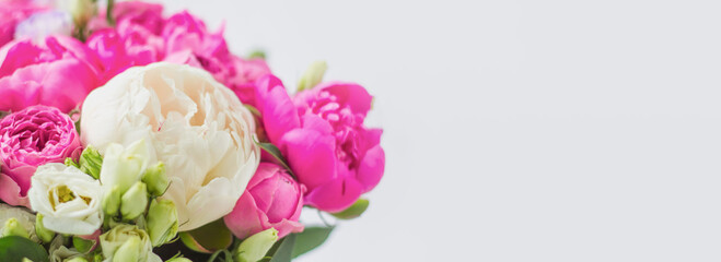 flowers in a hat box web banner. Bouquet of peonies, eustoma, spray rose in a pink box with an oasis on a white background
