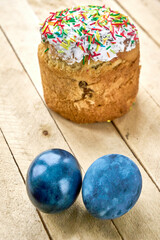 Pasca and blue painted eggs on a wooden background, vertical shot, vertical orientation