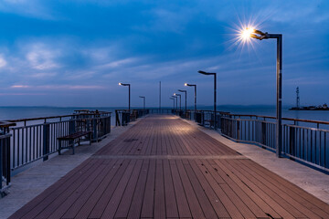 Side view of the pier on the Black Sea against the background of the sky and sunset