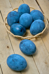 Blue painted eggs on a wooden background, vertical shot, vertical orientation