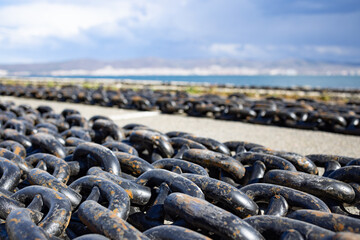 Chains for ships lies on the pier against the background of a cloudy sky and the Black Sea