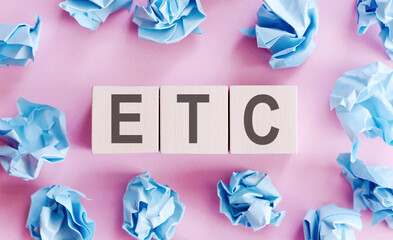 on a bright pale lilac and blue background, light wooden blocks and cubes with the text ETC.