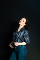 portrait of a young serious brunette on a dark studio background