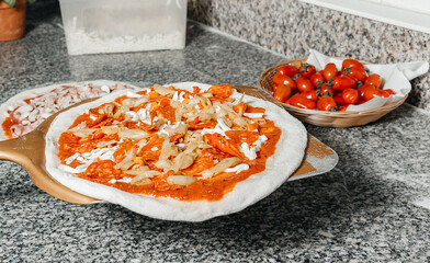 Process of placing pizza with mozzarella, tomato, cheese to oven at pizzeria