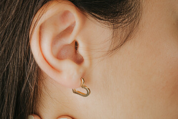 Jewelry, earrings in a beautiful girl's ear, women's accessories, gold earrings, earrings with...