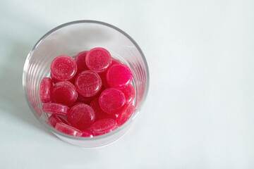 Red round tablets for the treatment of throat in a pillbox