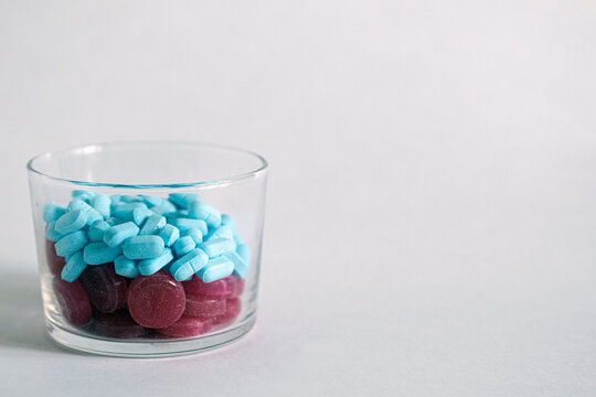 Red and blue tablets in a pillbox close-up, pillboxes are shifted to the left