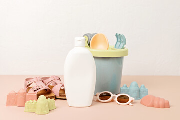 Kids summer accesories and sun screen bottle for sunny days and vacations. Sunglasses, sandals, sand molds for beach fun time