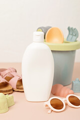 Kids summer accesories and sun screen bottle for sunny days and vacations. Sunglasses, sandals, sand molds for beach fun time