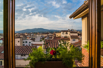 Fototapeta na wymiar Beautiful view from a window with flowers in Florence, Italy 