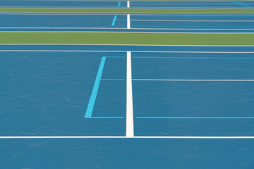 Blue tennis courts with white lines and light blue pickleball lines