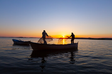 Lake fisherman at sunset 