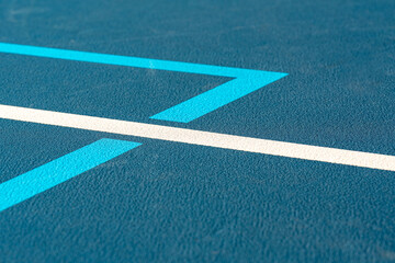 Blue tennis court with white lines and light blue pickleball lines
