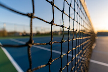 late afternoon close up of tennis court net.