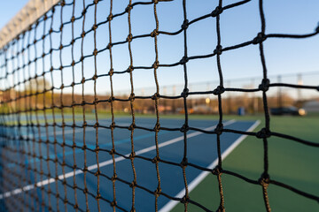 late afternoon close up of tennis court net.