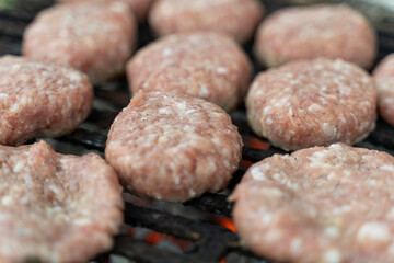 Meatballs are grilling on a portable barbecue outdoors.  Selective focus.