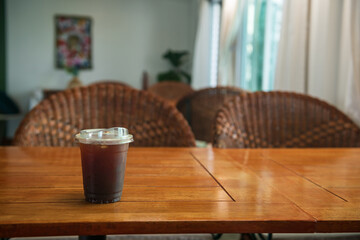 Naklejka na ściany i meble Ice Americano black coffee on wooden table at cafe