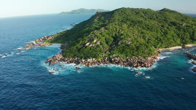Aerial pull back and tilt up from southern coast of La Digue island