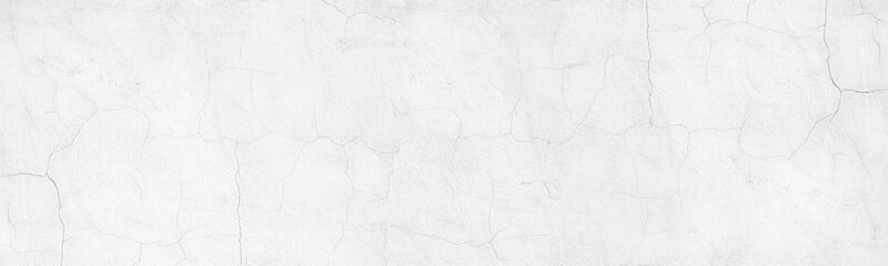 Whitewashed old cracked concrete wall wide panoramic texture. White painted plaster surface with thin cracks. Light gray abstract grunge background