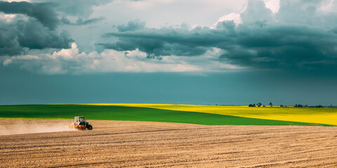Tractor Plowing Field In Spring Season. Beginning Of Agricultural Spring Season. Tractor Raised...