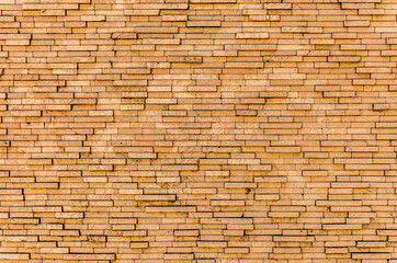 Yellow brick wall. Background of rectangular gray tiles of different sizes.