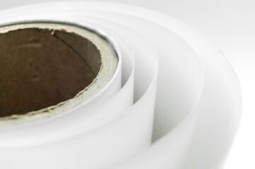 White polygraph paper on a cardboard spool. A bundle of leftover paper in a printing house....