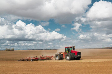 Red tractor on the plowed field.