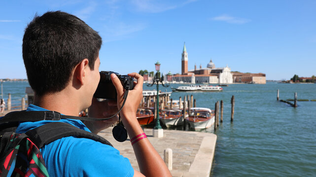 boy with black hair and the camera takes a picture at the church of Saint George called San Giorgio in italian language in Venice