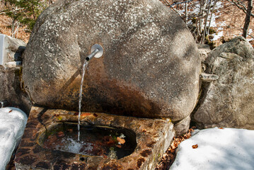 Stone mountain fountain with clear pure water running coming from nature spring with continuous pipeline