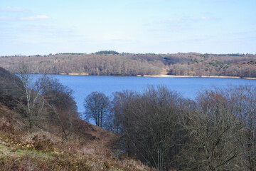 Landscape in early spring. A beautiful lake surrounded by hills with trees without leaves. Early spring. Spring landscape with trees by the river