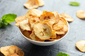 Dried banana chips, snack in white bowl © grinchh