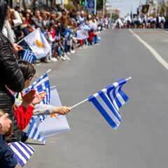 Greek Independence Day parade spectators with Greek and Cypriot flags, Limassol, Cyprus