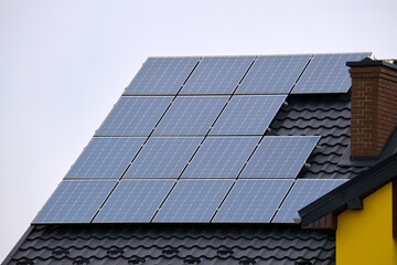 Private home roof covered with solar photovoltaic panels for generating of clean ecological electric energy in suburban rural town area. Concept of autonomous house