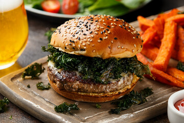 Juicy Beef burger with crispy kale, sweet potato fries and beer