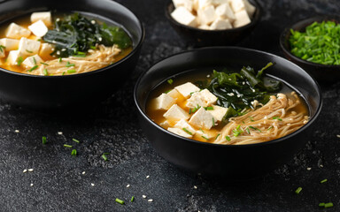 Rich miso soup with enoki mushrooms, wakame seaweed and tofu, vegetarian, vegan Asian food.