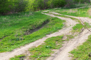 Obraz premium Winding dirt road on the flat countryside