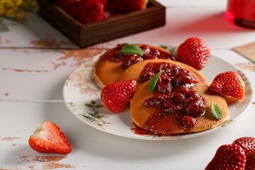 Les crêpes sur une assiette couvert de fraises et confiture de fraise