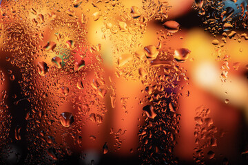 Raindrops on the glass against the background of night city lights