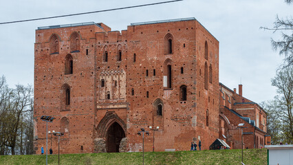 Ancienne cathédrale fortifiée du 13eme siècle de Tartu en Estonie en briques rouges avec de la verdure au premier plan par une journée nuageuse