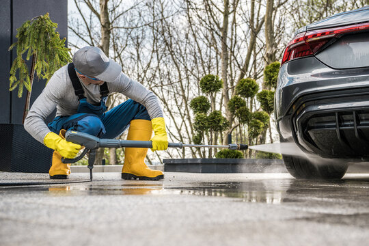 Men Pressure Washing His Car In Front Of A House