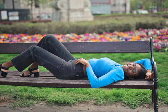 black woman lying on a bench relaxes