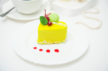 lemon yellow heart cake with cherries and cream on white background