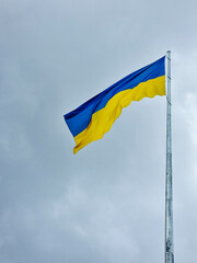 Ukrainian flag flutters on the flagpole. Blue and yellow colors, symbols the blue sky of Ukraine and yellow wheat field. Symbol of independence