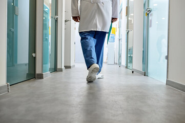 Doctor walking in hospital corridor rear view