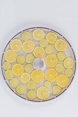 close-up, in a round grate, sliced fresh lemon and lime, for further drying